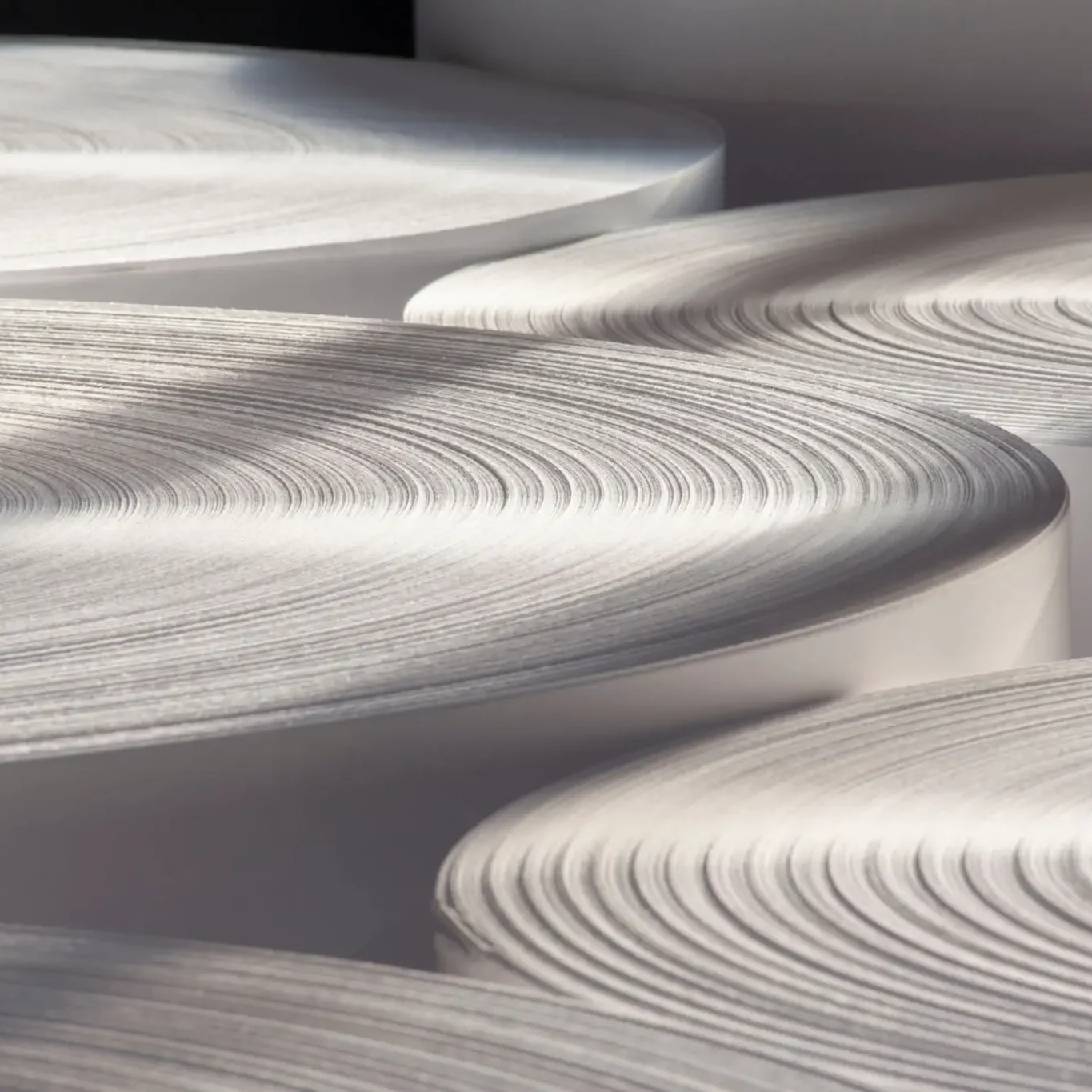 Large rolls of white paper stacked together.